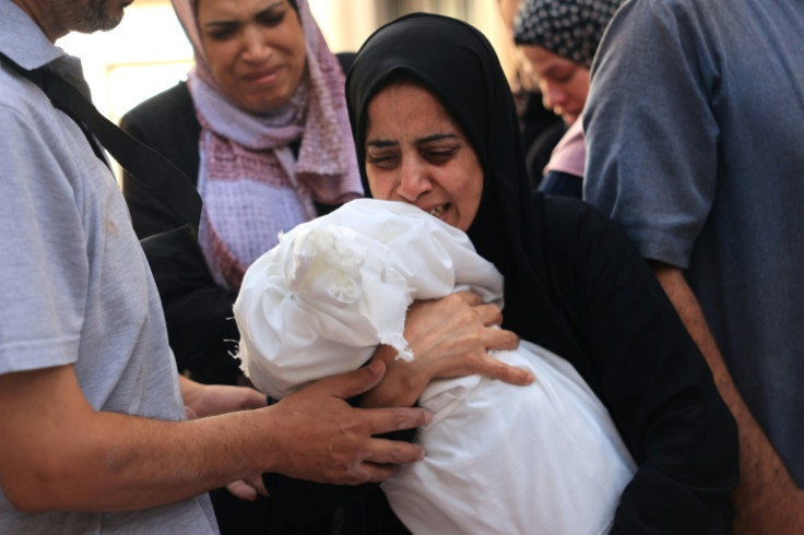 Relatives carry the body of an eight-month-old child in Rafah in the southern Gaza Strip on November 6, 2023
