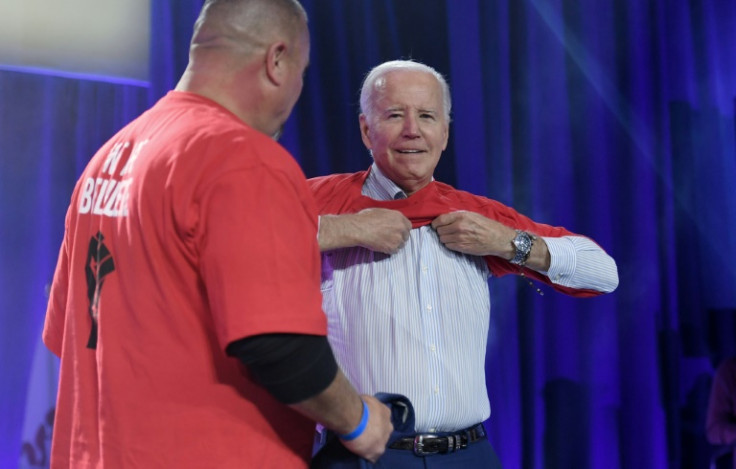 US President Joe Biden puts on a local United Auto Workers shirt