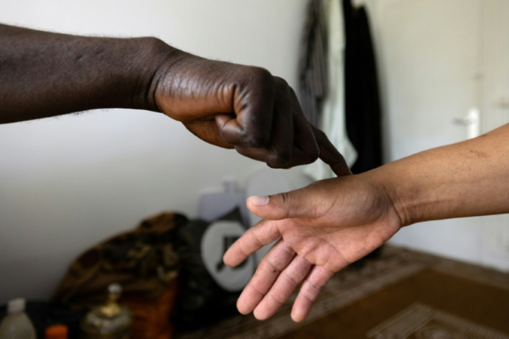 African faith healer Sheikh Issa tests the hand of his client Raymond before a consultation