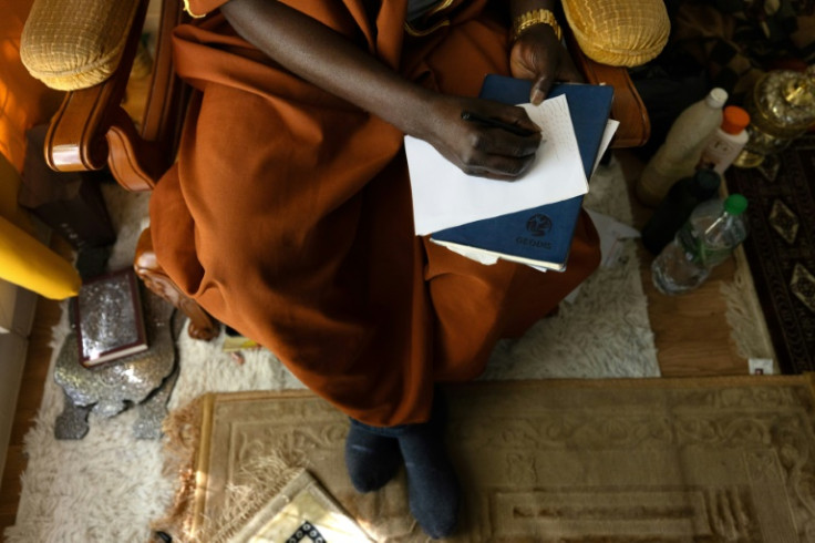 African faith healer Sheikh Issa takes geomantic notes during a consultation near Paris