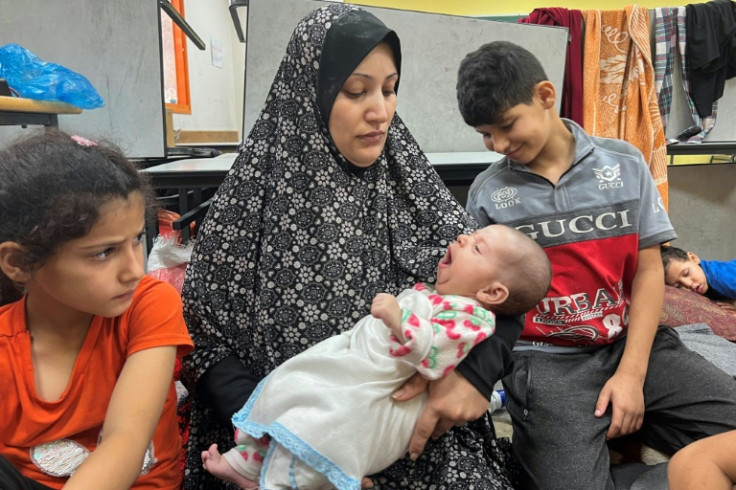 Gaza mother Fadwa Kullab holds her newborn Mohammad inside a UN-run shelter in Rafah in the southern Gaza Strip