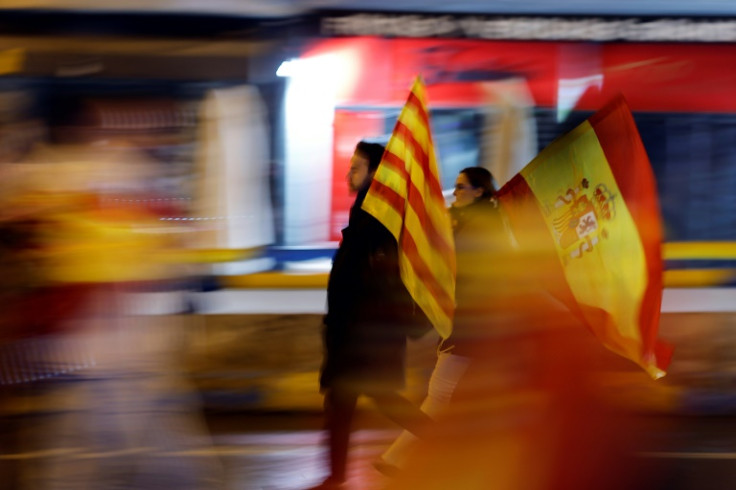 People carrying the Catalan (L) and Spanish flags during a protest over the Catalan amnesty deal