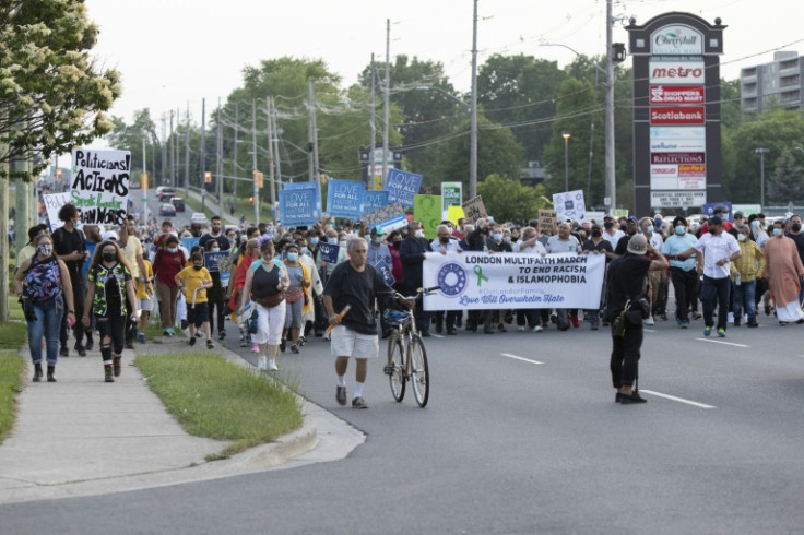 People in June 2021 march past the parking lot where murder and terror suspect Nathaniel Veltman was arrested, calling for an end to hatred following his killing of a Muslim family out for a Sunday evening stroll earlier in the month