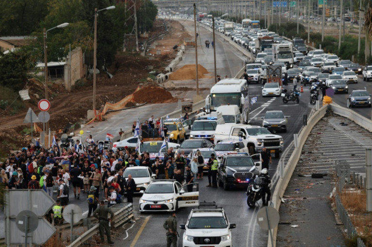 Israelis march on a highway from Tel Aviv as part of a protest for the release hostages taken in the Hamas attack