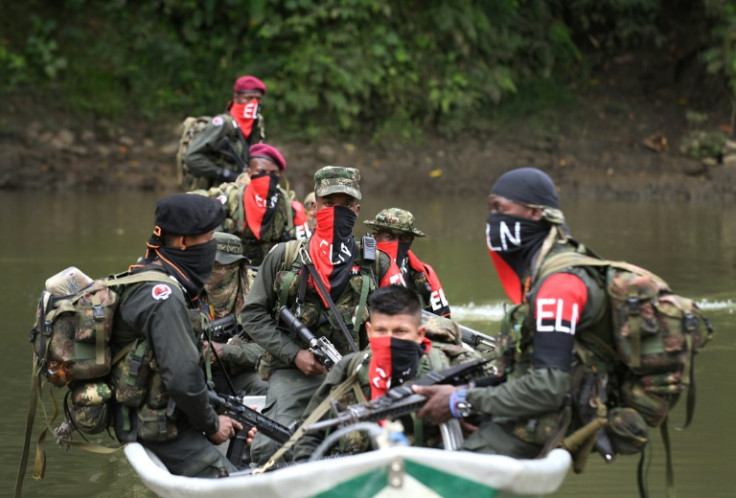 The ELN rebels disguise their faces with red and black coverings; they are heavily armed