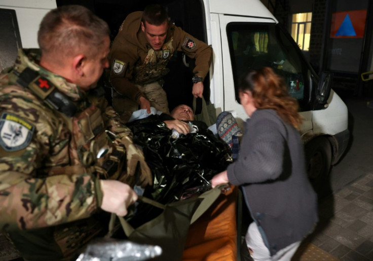 A wounded man evacuated by policemen from the frontline town of Avdiivka in east Ukraine
