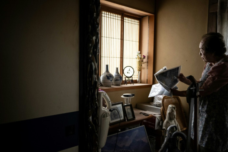 Beauty adviser Tomoko Horino looks through old photos at her house in Fukushima city