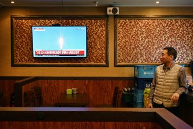 A man watches a television showing a news broadcast at a restaurant in Seoul late Tuesday