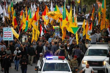 Iraqi mourners in Baghdad carry the coffin of a Kataeb Hezbollah fighter who was also part of the 'Islamic resistance in Iraq,' which has claimed recent attacks against US troops in Iraq and Syria, and who is believed to have died in a US air strike