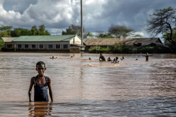 Children play and swim in an inundated football pitch in Garissa