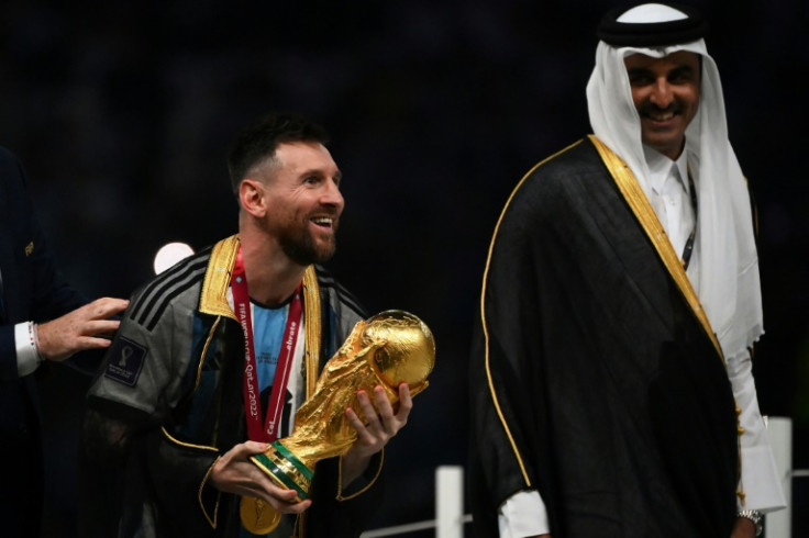 Lionel Messi holds the World Cup trophy next to Qatar's Emir Sheikh Tamim bin Hamad al-Thani after Argentina's victory in 2022