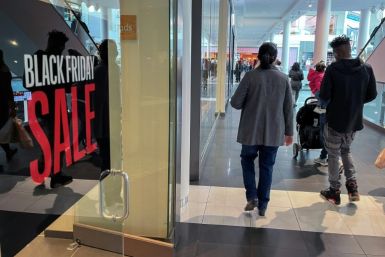 A family walks past a store advertising a Black Friday sale near Pentagon City Mall in Arlington, Virginia