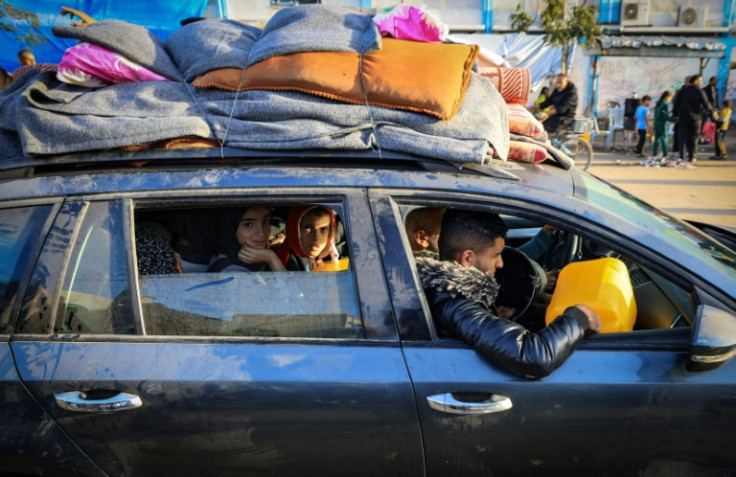 Palestinians who had taken refuge in temporary shelters return to their homes in eastern Khan Yunis, the southern Gaza Strip, during the first hours of a four-day truce between Israel and Hamas militants