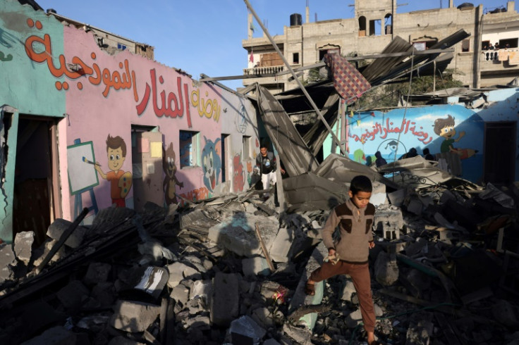 A child walks amid the rubble of a Rafah school hit during a strike before the start of a four-day truce