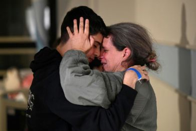 Sharon Avigdori embraces her son, at Sheba Medical Center in Israel, after she was released along with her daughter from Hamas captivity