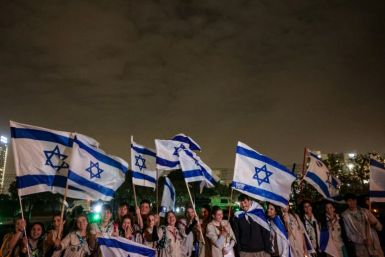 Israeli scouts wave flags of Israel next to the Schneider Hospital as they wait for the release of hostages in Petah Tikva near Tel Aviv