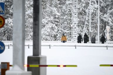 Finnish Border Guards escort two migrants at the Raja-Jooseppi international border crossing station in Inari, northern Finland, on November 27, 2023