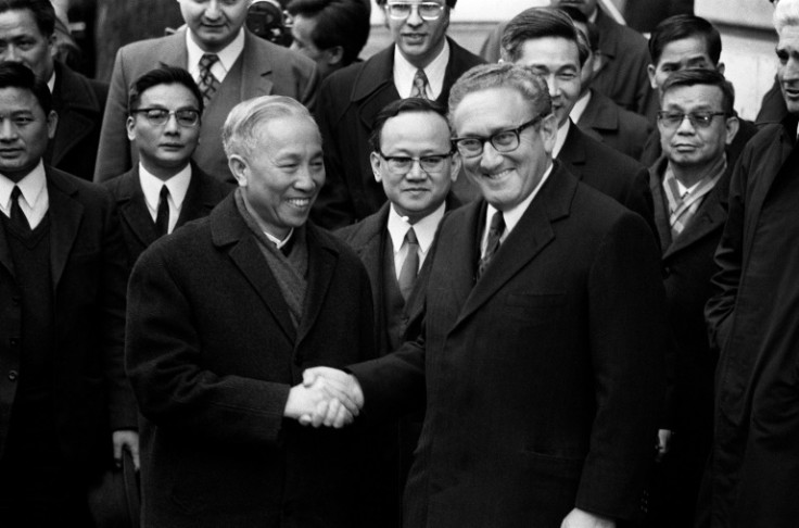 Henry Kissinger shakes hands with North Vietnamese negotiator Le Duc Tho as they sign an agreement in Paris in January 1973 that effectively ended US military operations