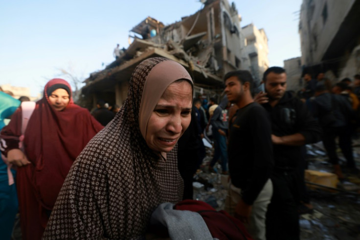 A Palestinian woman reacts as people check the rubble of a building destroyed in the Rafah refugee camp as Israeli air strikes resumed after a truce between Israel and Hamas militants expired