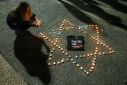 A woman lights candles during a gathering in Tel Aviv demanding the release of Israelis held hostage in Gaza