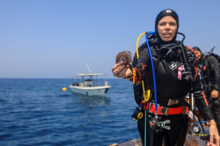 A volunteer diver shows fishing nets removed from coral reefs at Oman's Dimaniyat islands