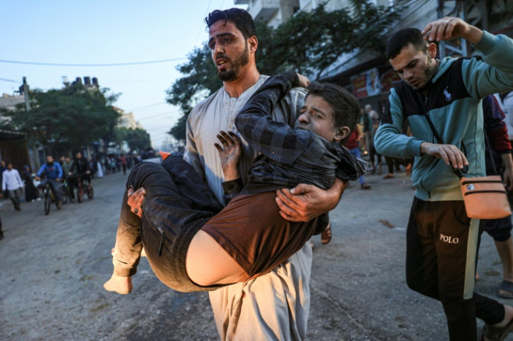 Palestinians help a boy injured in an Israeli strike in Rafah in the southern Gaza Strip on December 3, 2023