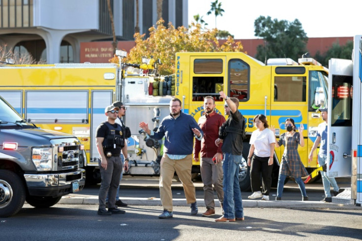 Security agents escort people off the University of Nevada, Las Vegas, campus to safety after the shooting  on December 6, 2023