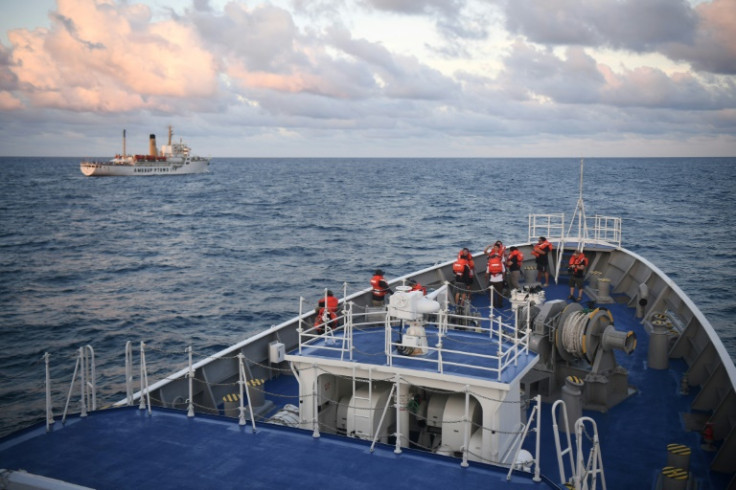 Philippine Coast Guard ship Melchora Aquino watches over a Philippine civilian ship (L), loaded with provisions for Filipino fishermen and troops
