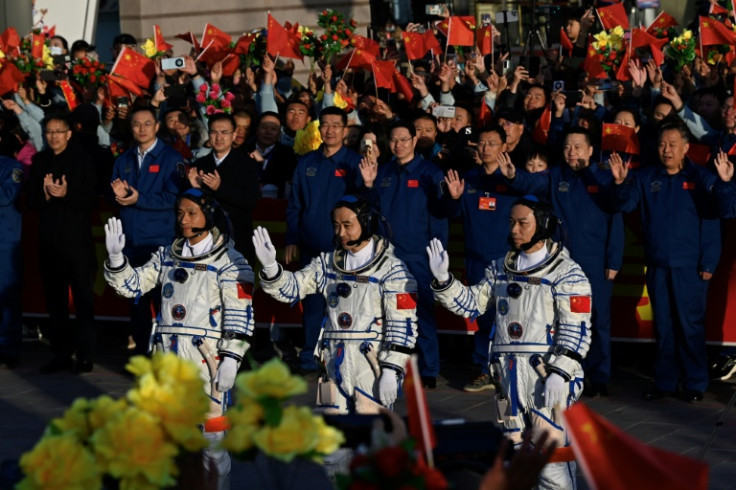 Chinese astronauts Jiang Xinlin, Tang Shengjie and Tang Hongbo wave before boarding the Shenzhou-17 spacecraft on October 26, 2023