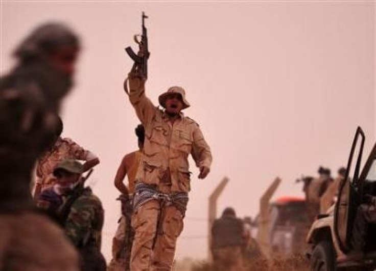 A rebel fighter holds a weapon during a shootout with forces loyal to Libya&#039;s leader Muammar Gaddafi on the outskirts of Al-Briqa, west of Ajdabiyah