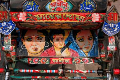 A bicycle rickshaw adorned with colourful artwork depicting film actors, in Dhaka