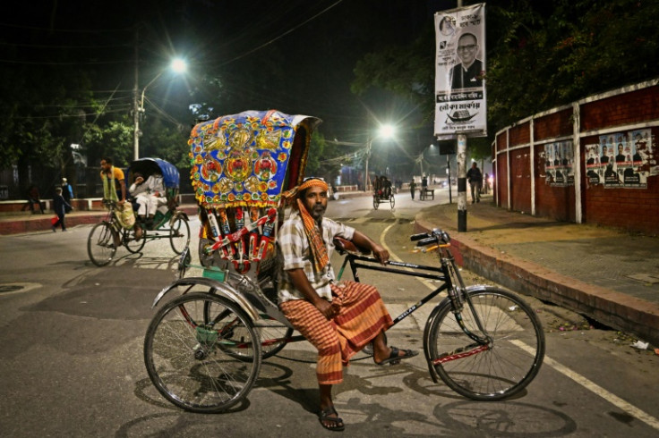 Bicycle rickshaw driver Mohammad Raju Mia poses for a portrait with his vehicle on a street in Dhaka