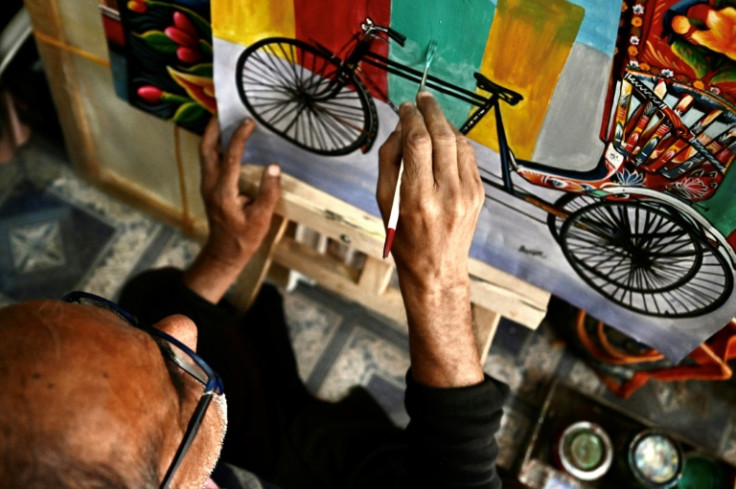 Rickshaw artist Hanif Pappu works on a painting at his shop in Dhaka