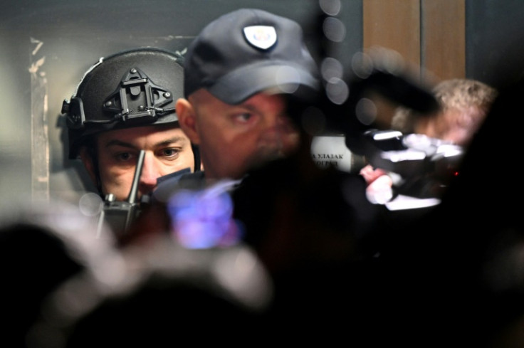 Police officers guard the entrance of a local police station  during a protest in Belgrade, a week after the parliamentary and local elections