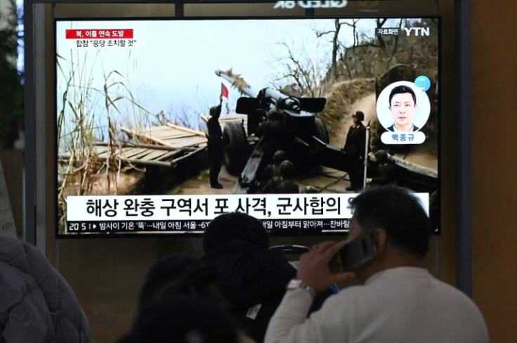People at a railway station in Seoul watch a news broadcast with footage of one of North Korea's artillery firings