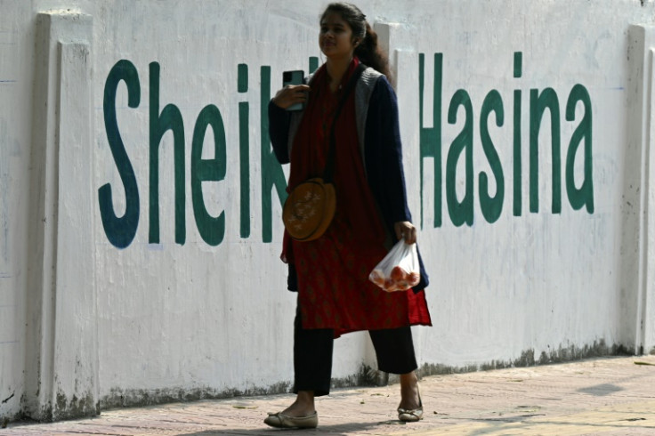 A woman walks past a wall praising Prime Minister Sheikh Hasina in Dhaka on January 6. Supporters point to her economic achievements, critics to her  record on human rights