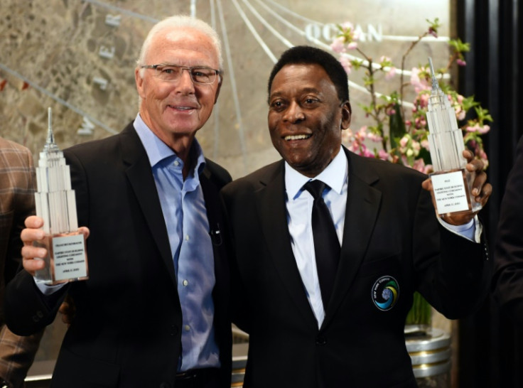 New York Cosmos soccer legends Pele (right) and Franz Beckenbauer pose after they "flip the switch" at the  Empire State Building April 17, 2015 in New York to launch the start of the teams 2015 spring season.