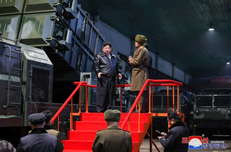 Kim Jong Un (L) inspects a missile launcher while touring North Korean munitions facilities