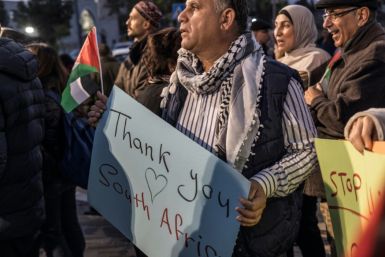 People in Ramallah in the West Bank celebrate the landmark "genocide" case South Africa has filed against Israel at the ICJ