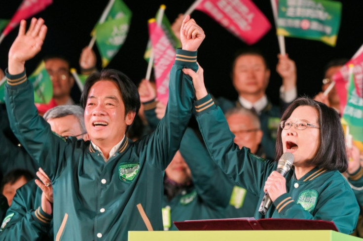 Taiwan's President Tsai Ing-wen (R) joins hands with presidential candidate of the ruling Democratic Progressive Party Lai Ching-te during a campaign rally