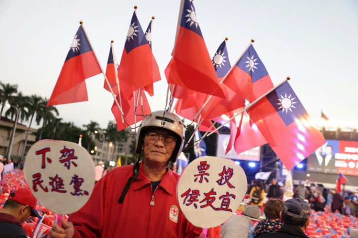 A supporter carries Taiwanese flags during a campaign rally of the main opposition Kuomintang (KMT) party