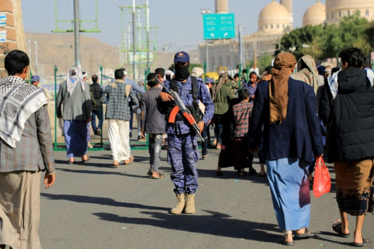 A fighter loyal to Yemen's Huthi rebels stands guard in Sanaa during a protest following US and British strikes