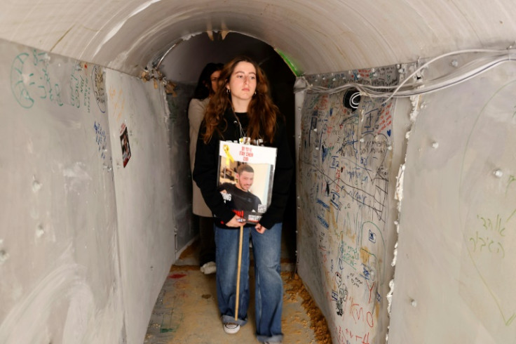 A relative carries a portrait of Israeli hostage Itay Chen as she walks through a replica in Tel Aviv of the Gaza tunnels where the hostages are believed to be held