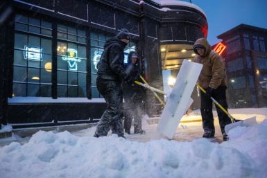 Men shovel snow in Ankeny, Iowa, on January 12, 2024, as record-breaking cold continues to complicate the Iowa caucuses