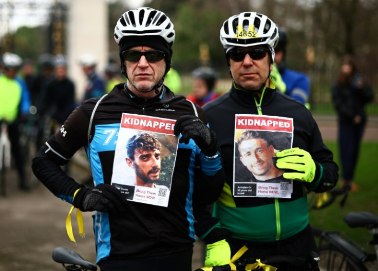 Cyclists hold posters of missing Israeli hostages after taking part in a bike ride in Regent's Park, London, marking 100 days since Hamas took 250 captive