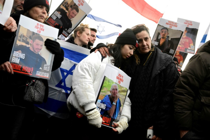Efrat Machikawa (R) and Aya Machikawa (C) hold a poster with the portrait of their relative Gadi Moses, who is one of the Israeli hostages held by Hamas, during the march in Berlin