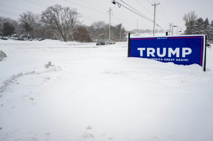 A campaign placard stands in the snow outside the campaign headquarters of former US president and 2024 White House hopeful Donald Trump in Urbandale, Iowa, on January 13, 2024