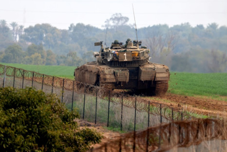 An Israeli battle tank rolls at a position along the border with the Gaza Strip