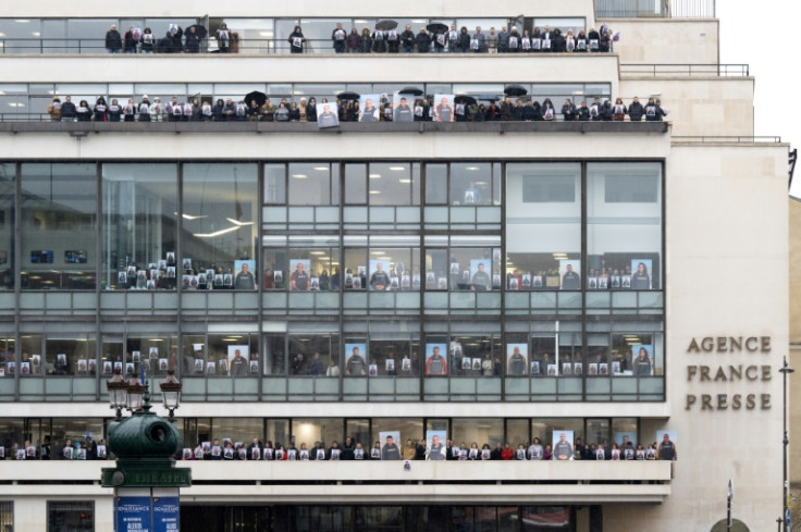 AFP journalists held up portraits of their colleagues in Gaza at the agency's Paris headquarters