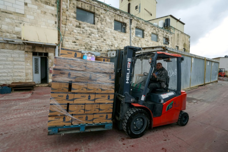 An employee transports boxes at Bishara Jubran's household products and cosmetics factory in the occupied West Bank city of Ramallah, who was able to keep his factory afloat by selling washing powder and other household products